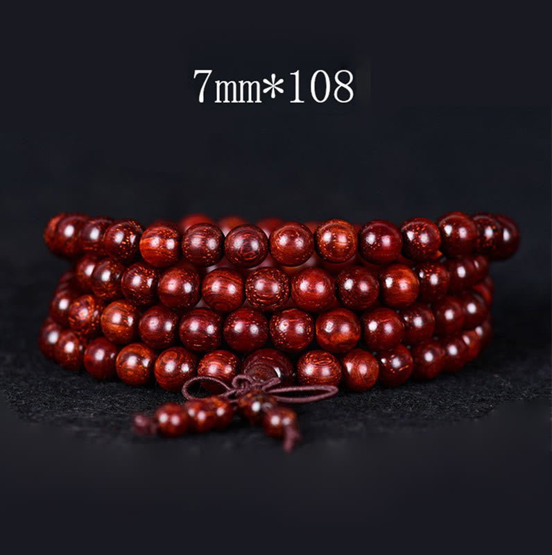 Rotes Sandelholz Armband mit 108 Perlen auf dunklem Hintergrund Detailaufnahme