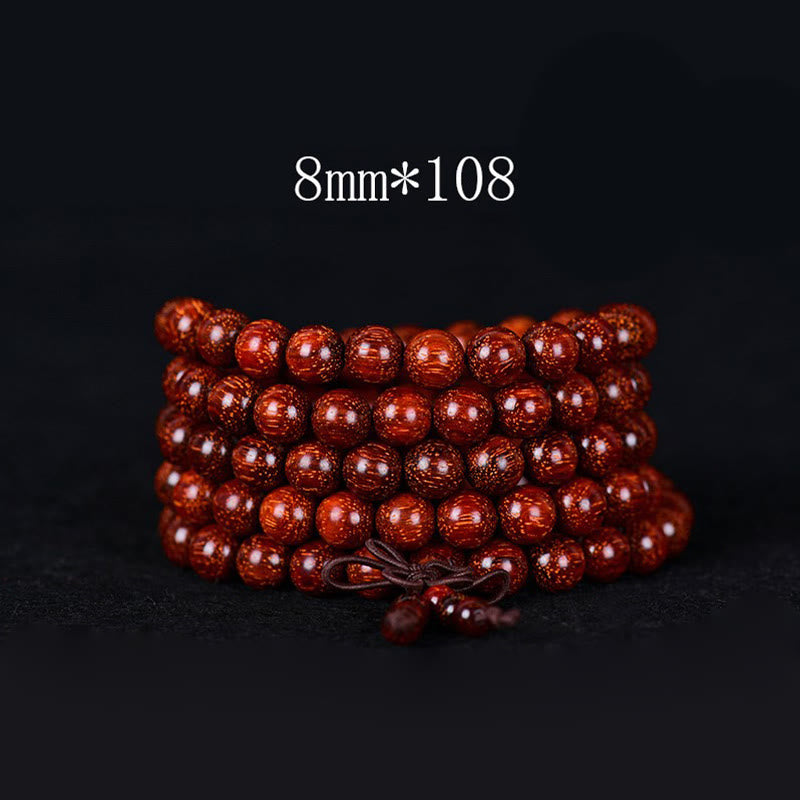 Rotes Sandelholz Armband mit 108 Perlen Nahaufnahme schwarzer Hintergrund Meditation Balance