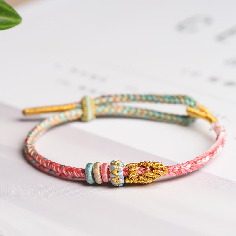 Geflöchteltes Armband mit Friedensknoten in Rosa und Grün Farben Nahaufnahme