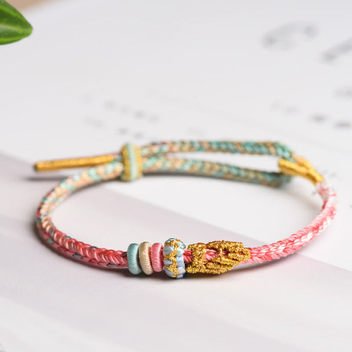 Geflöchteltes Armband mit Friedensknoten in Rosa und Grün Farben Nahaufnahme