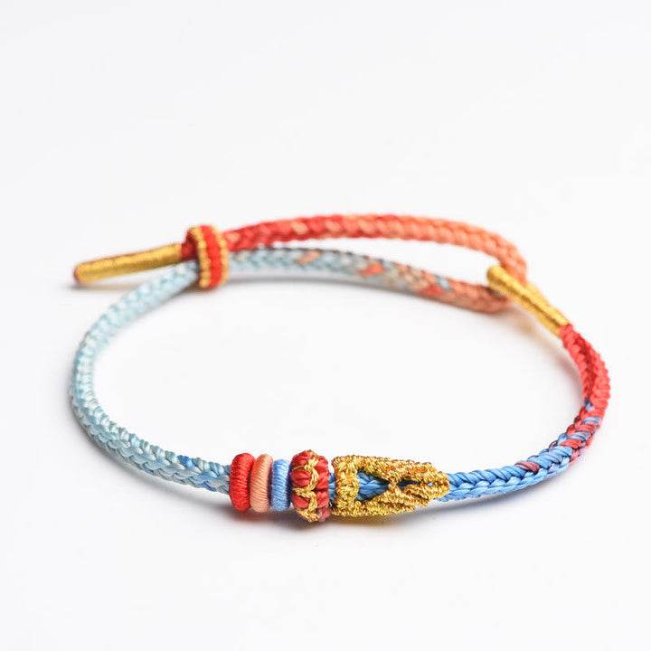 Gewebtes Armband Friedensknoten rot blau gold Schutz Glück Makroaufnahme