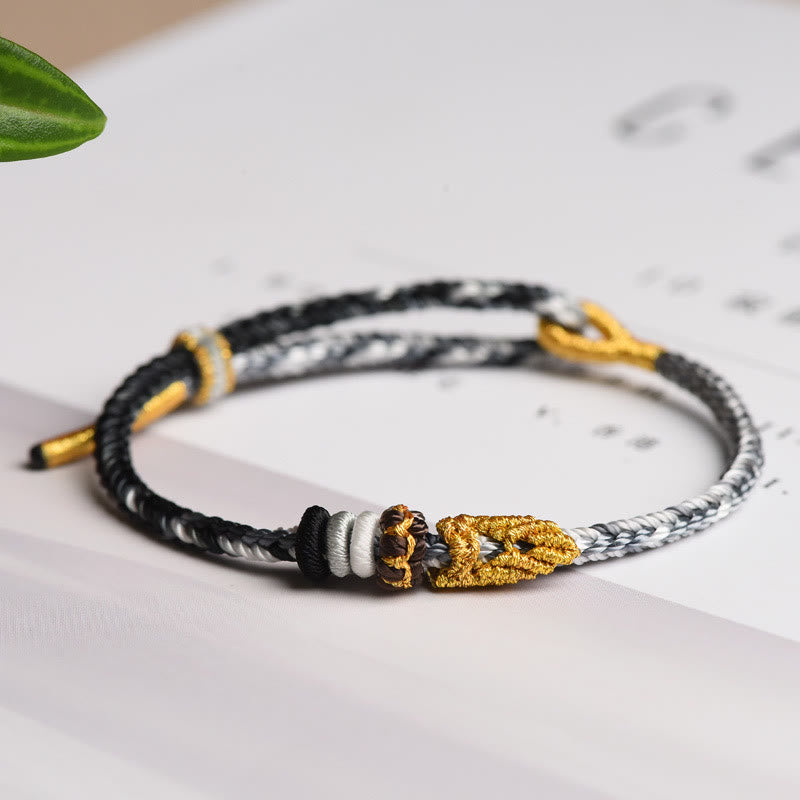 Geflochtenes Armband mit Friedensknoten, schwarzweiß geflochten, goldener Verschluss, Flachlage