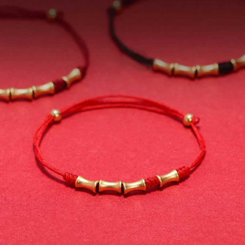 Rotes Armband mit goldenen Bambus-Perlen elastisch getragen Glück Schutz.