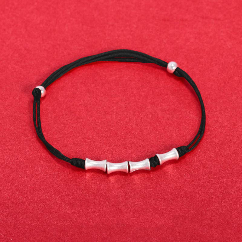 Schwarzes Armband 925 Silber Bambus mit elastischem Stoffband auf rotem Hintergrund.