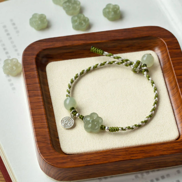 Jade Pflaumenblüte Armband mit grünen Steinen und geflochtenem Seil.