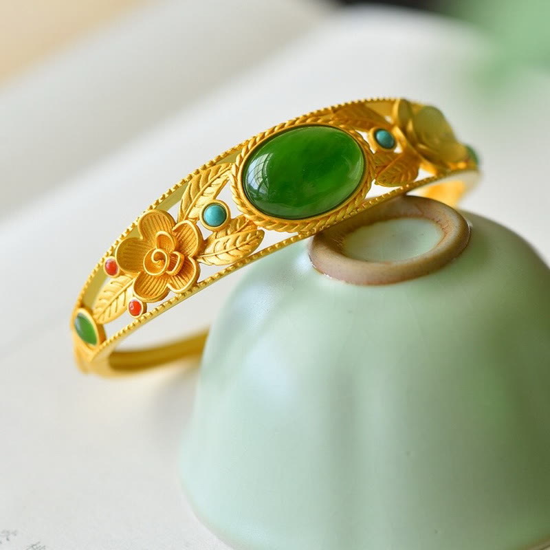 Goldenes Armband mit grüner Jade und türkisen Steinen elegant präsentiert.