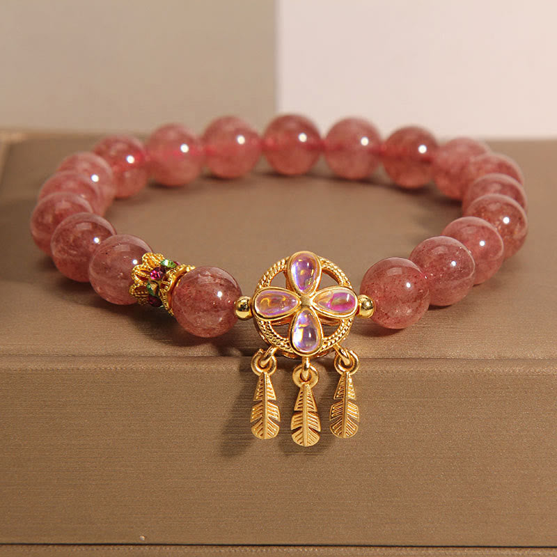 Armband Erdbeerquarz Kleeblatt – Liebe mit goldenen Blattanhängern elegant präsentiert.