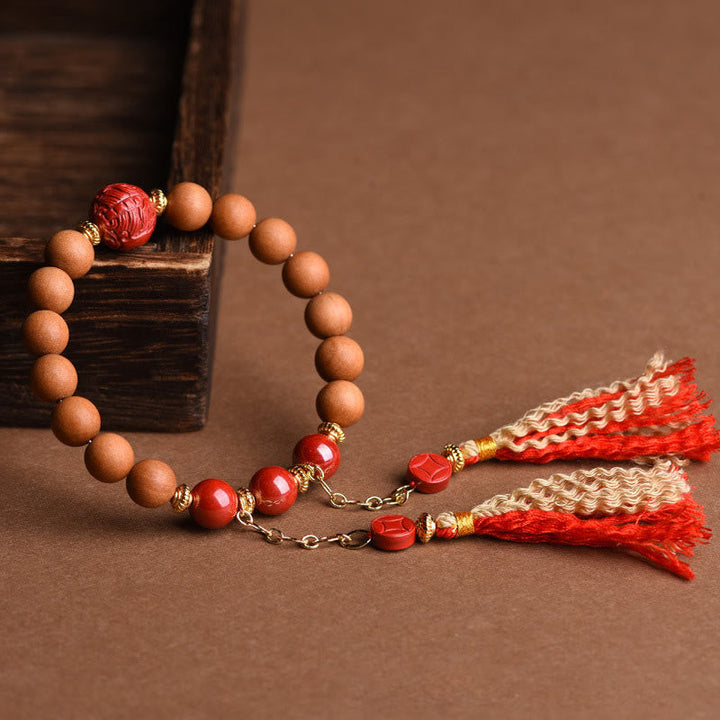 Holzperlen-Armband mit roten Akzenten und Quasten-Anhänger elegant.