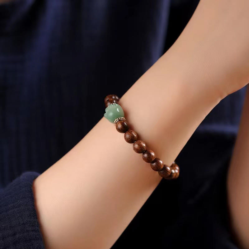 Sandelholz Armband mit grünem Stein am Handgelenk eleganter Schmuck