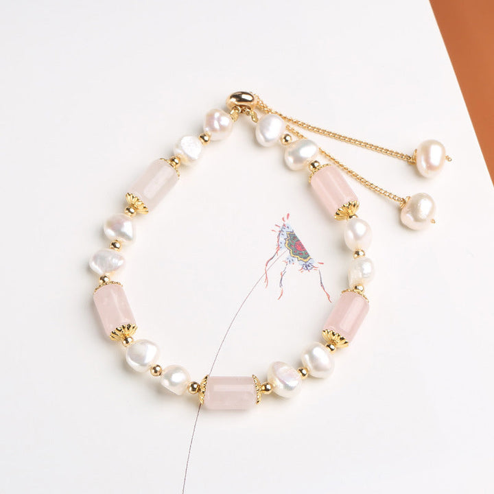 Armband mit Perlen und rosa Stein Anhängern gold verziert elegant