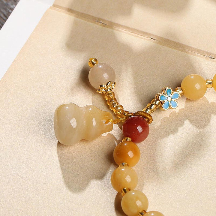 Jade Armband Gold mit Perlen und Blütenanhänger elegant.