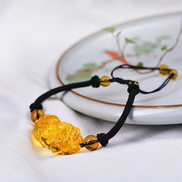 Gelbes Bernstein Armband mit schwarzer Kordel und Perlen elegant.