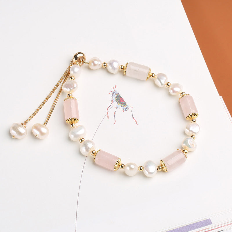Elegantes Armband mit Perlen und rosa Kristallen, Golddetails.