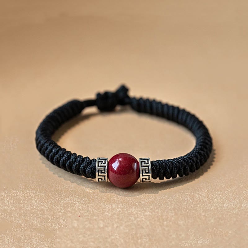 Schwarzes Armband mit rotem Zinnober Stein und silbernen Verzierungen elastisch.