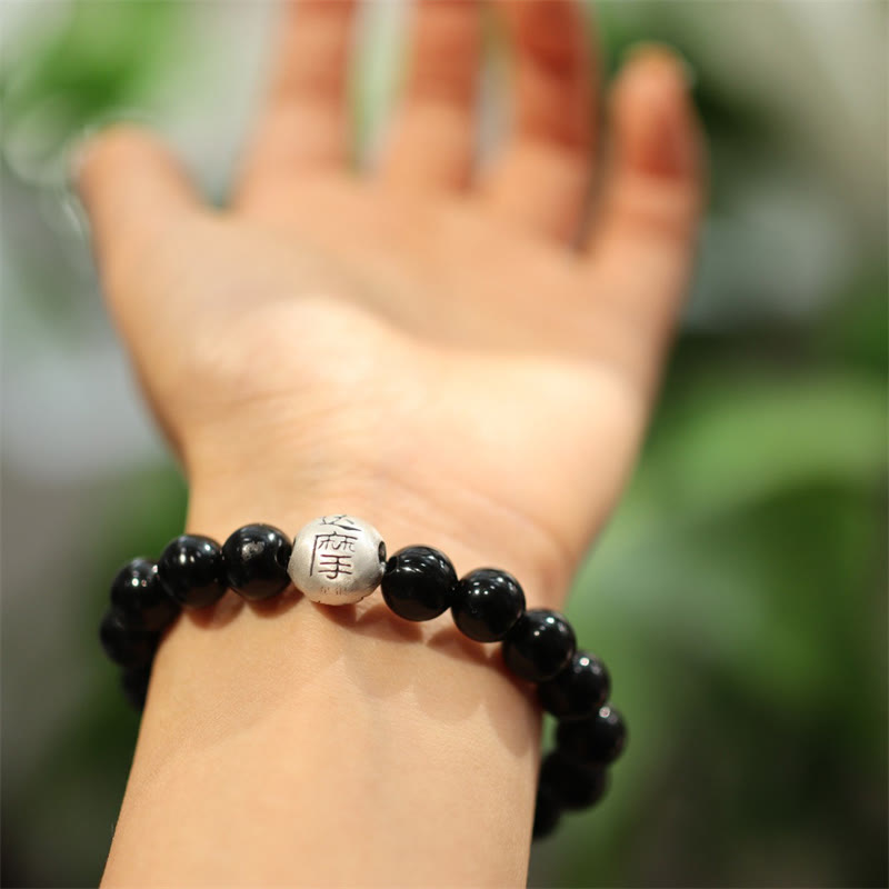Schwarzes Onyx Armband mit Silberperle am Handgelenk getragen elegant