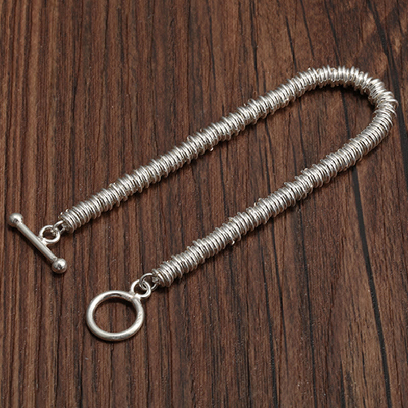 Silbernes Spiralarmband Circle Glück auf Holzhintergrund elegant.