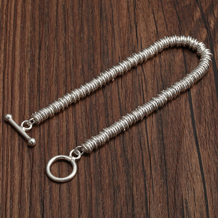 Silbernes Spiralarmband Circle Glück auf Holzhintergrund elegant.