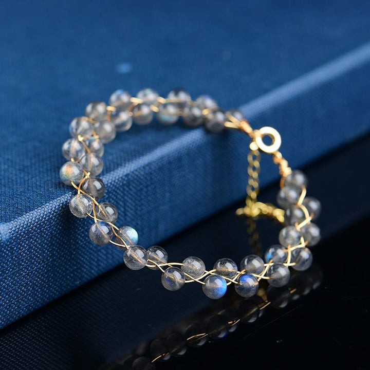 Mondstein Armband mit goldenen Perlen auf blauem Stoff, Nahaufnahme elegantes Design Liebe & Segen