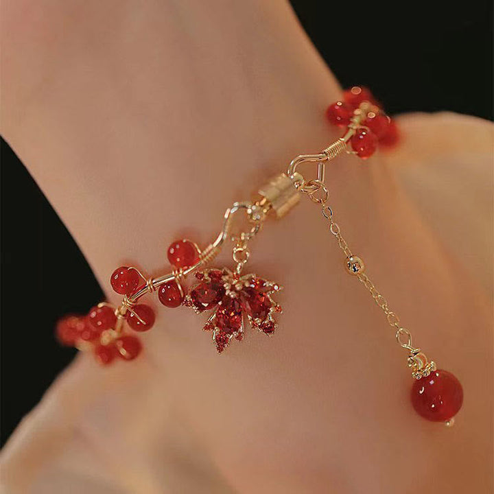 Rotes Ahornblatt Armband mit Perlen elegant am Handgelenk getragen Glück
