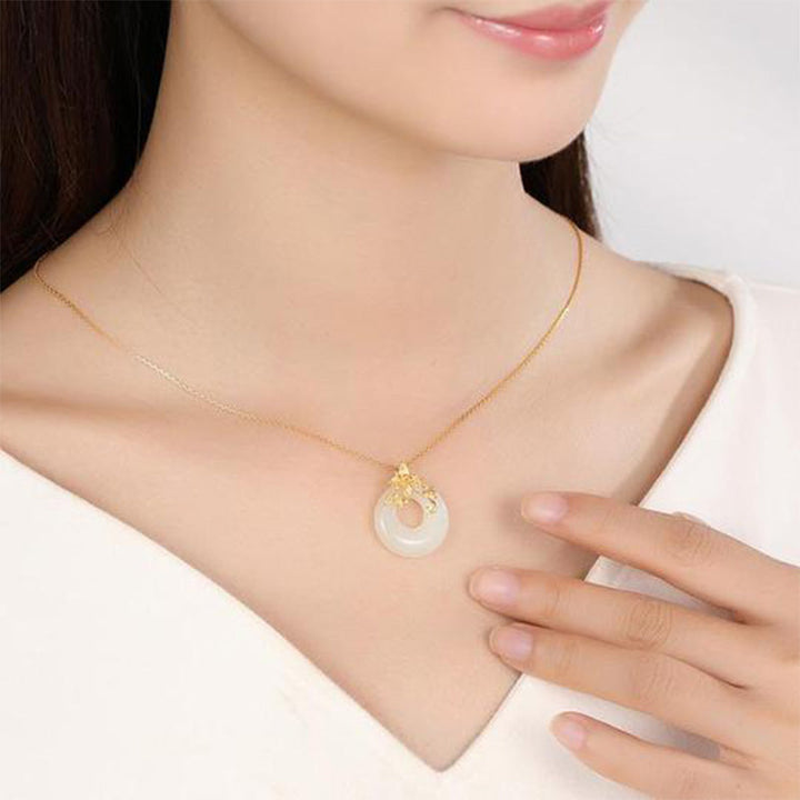 Goldene Kette Jade Blüte Anhänger elegant am Hals getragen
