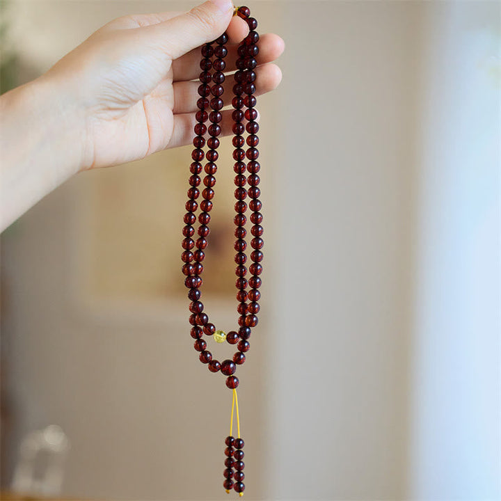 Mala 108 Perlen Amber – Energie Halskette in Hand gehalten braun