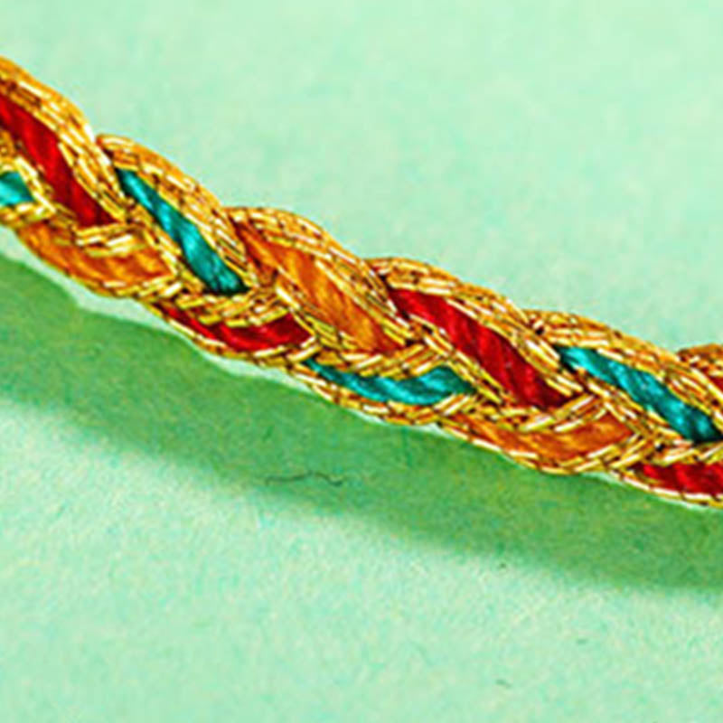 Armband Bunt Drachen Scale Geflochten Gold Rot Blau auf grünem Hintergrund