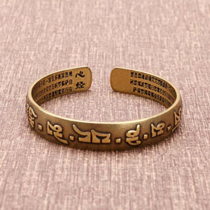 Armband Kupfer Om Mani Padme Hum mit Gravur auf Leinen Untergrund.