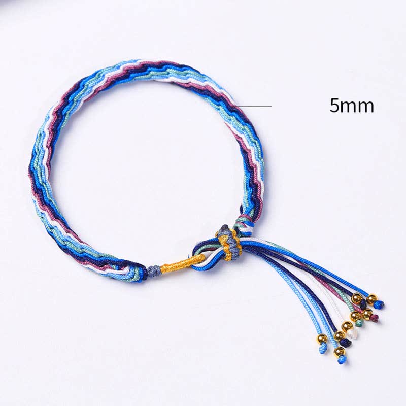 Buntes Samsara Knot Armband mit blauen und roten Fäden, Flachaufnahme.