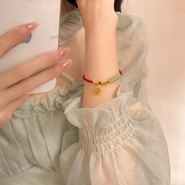 Jade Fu-Zeichen Armband rote Schnur goldene Perlen Handgelenk getragen