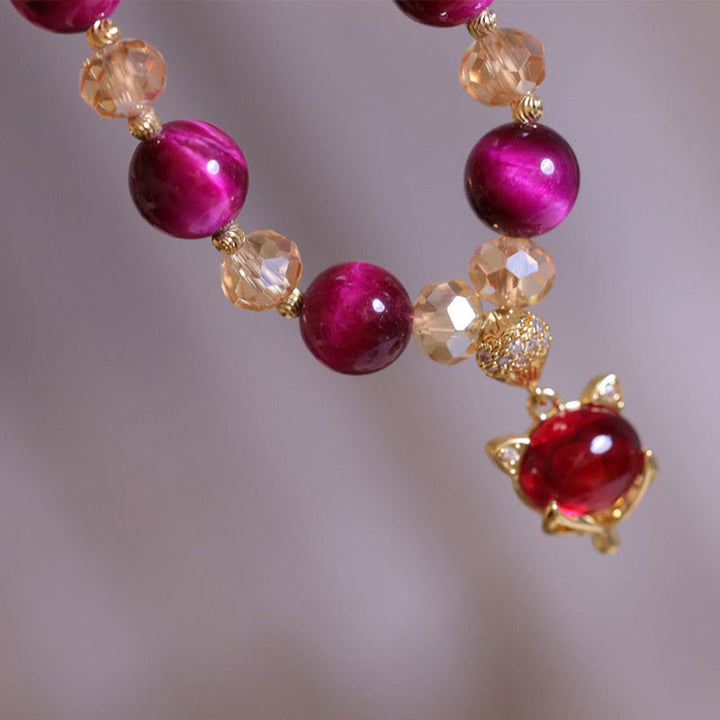 Elegantes Armband mit magenta Perlen und goldenem Pixiu Anhänger glänzend
