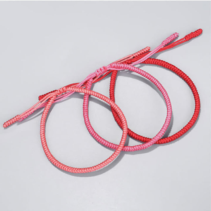 Tibetisches geflochtenes Armband Set in Rosa und Rot, drei Stück.