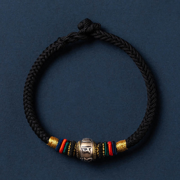 Geflochtenes schwarzes Armband mit silbernem Om Mani Padme Hum Anhänger.