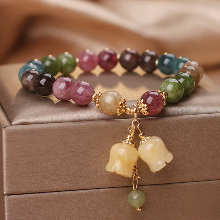 Buntes Tourmaline Armband mit Blumen-Perlen-Anhänger auf Schmuckbox.