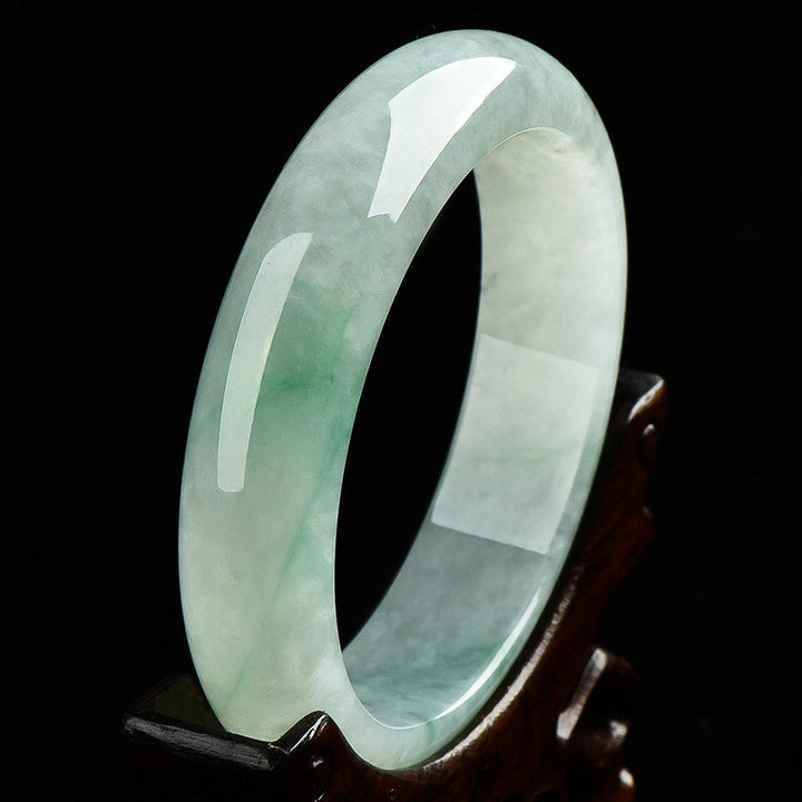 Armband Jade hell grün weiß Naturstein glänzend poliert Holzständer.