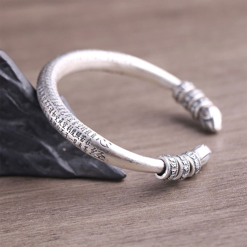 Silbernes Om Mani Padme Hum Armband mit Gravur auf Holz.