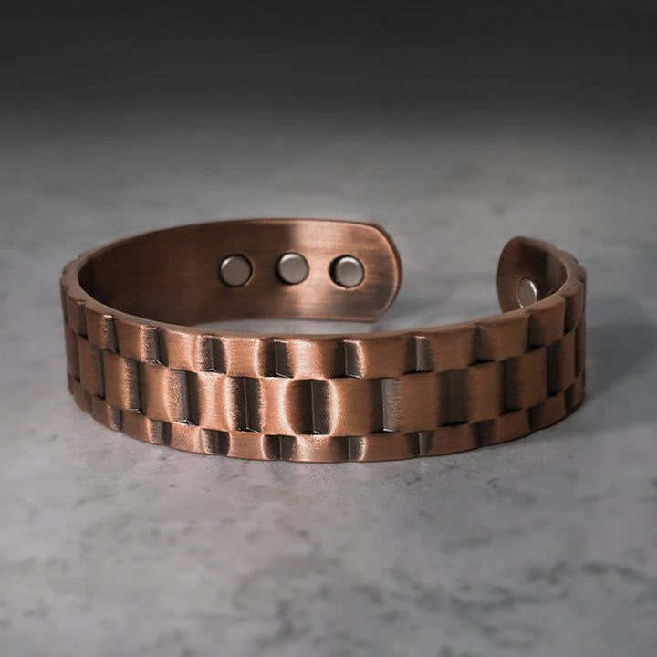 Kupfer Armband mit geometrischem Muster auf grauem Marmor Hintergrund