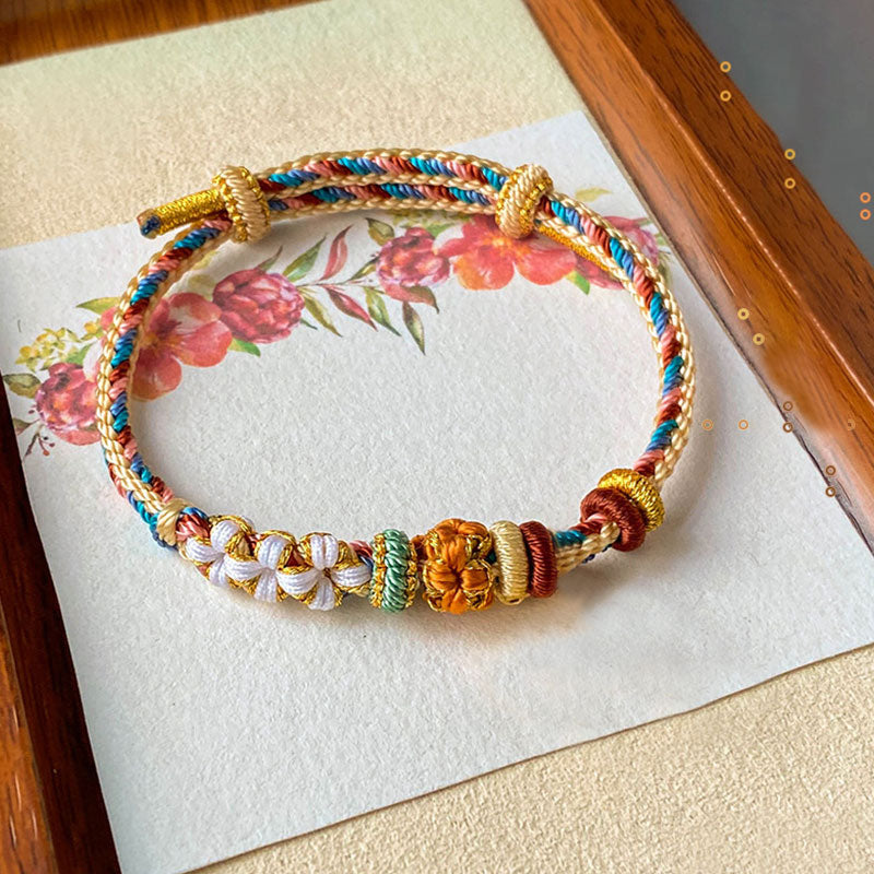 Armband Pfirsichblüte mit bunten Fäden und goldenen Perlen handgefertigt