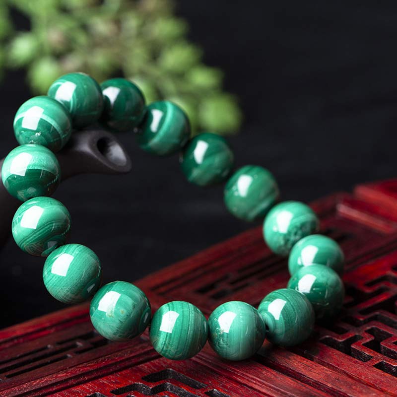 Mala Malachit Armband Grün Naturstein glänzend auf rotem Holz Nahaufnahme