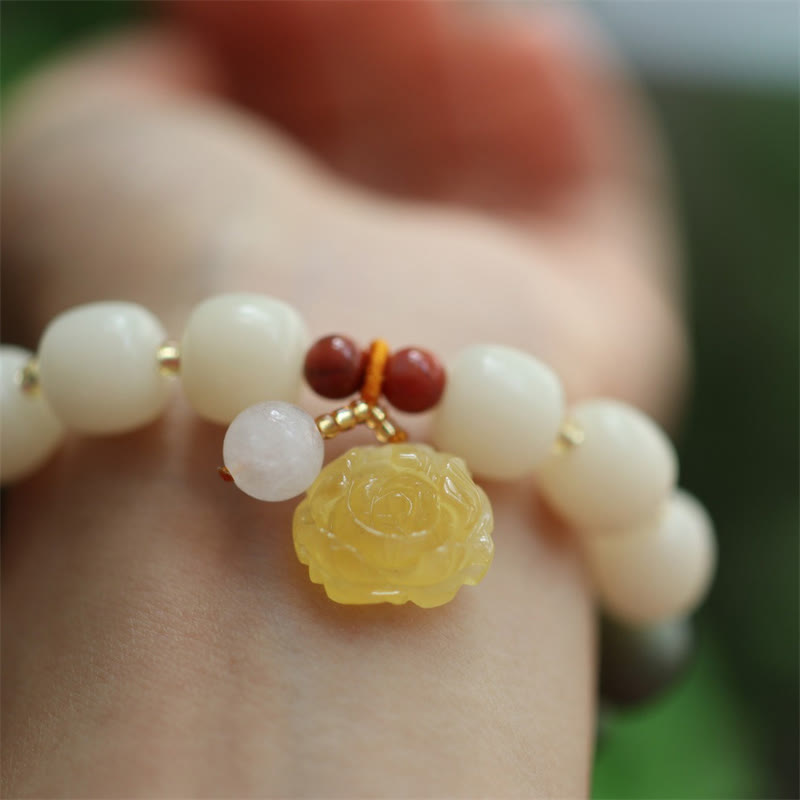 Bodhi Lotus Armband mit weißen Perlen und gelbem Stein am Handgelenk