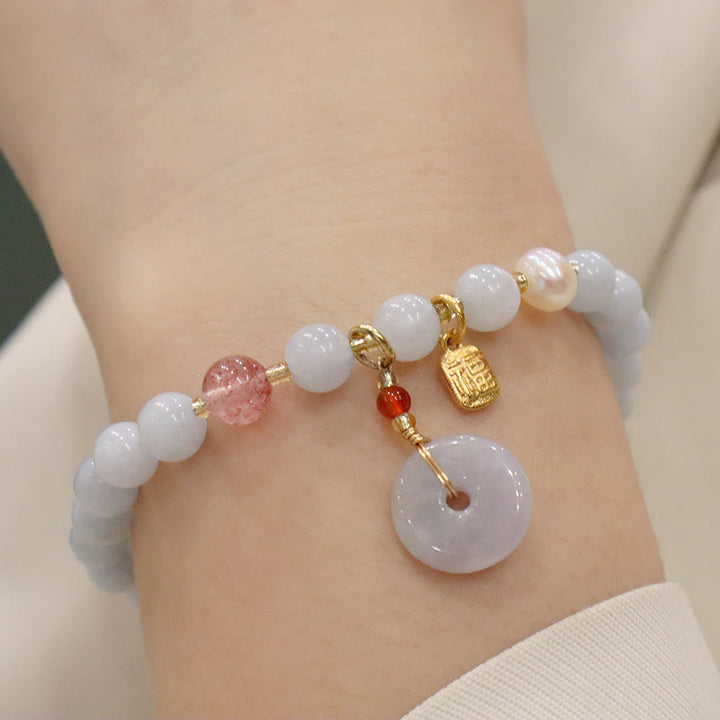 Jade Armband mit weißen Perlen und Anhängern elegant getragen.