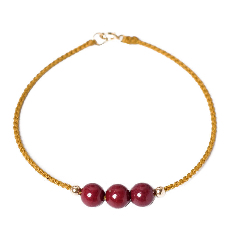 Armband Zinnober mit drei roten Perlen goldene Kette elegant