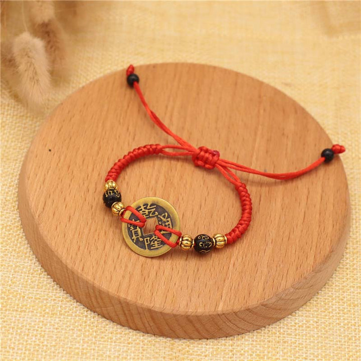 Rotes Armband Kupfer – Glück mit chinesischen Münzen Holzplatte.