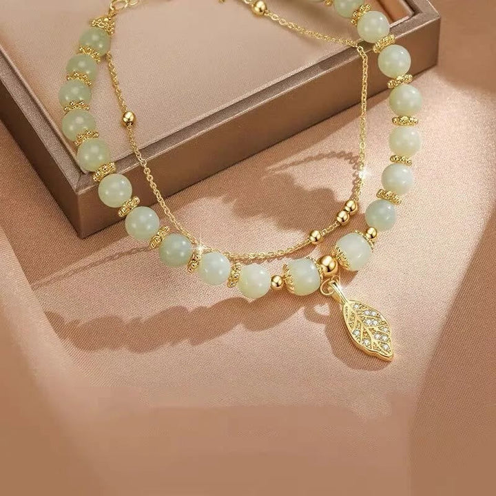 Jade Armband mit goldenen Perlen und Blatt-Anhänger elegant.