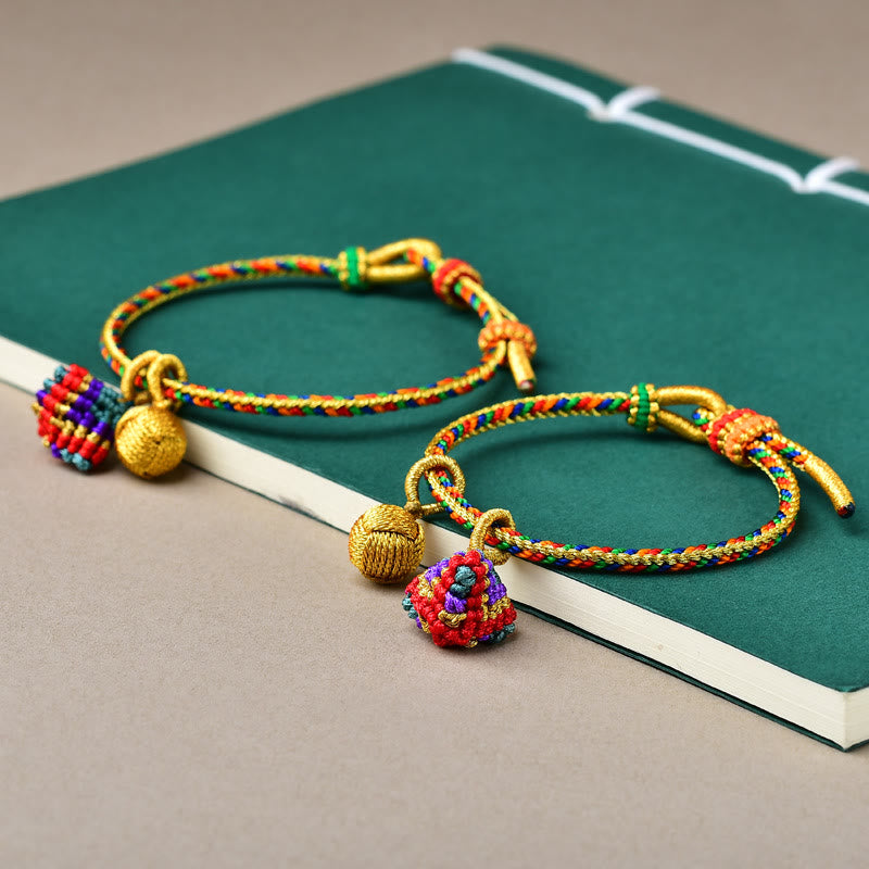 Bunte Armbänder mit goldenen Perlen und Zongzi Anhängern elegant präsentiert.