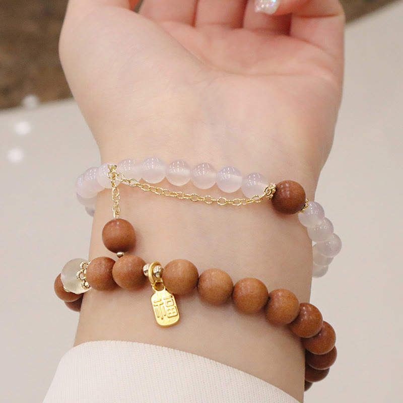 Armband Sandelholz Fu-Zeichen Schutz rosafarbene Perlen Handgelenk getragen