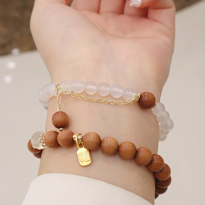 Armband Sandelholz Fu-Zeichen Schutz rosafarbene Perlen Handgelenk getragen