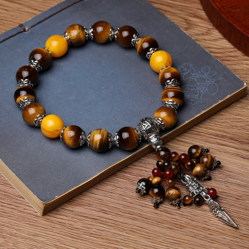 Tigerauge Armband mit Silber Drachen Perlen auf grauem Notizbuch.