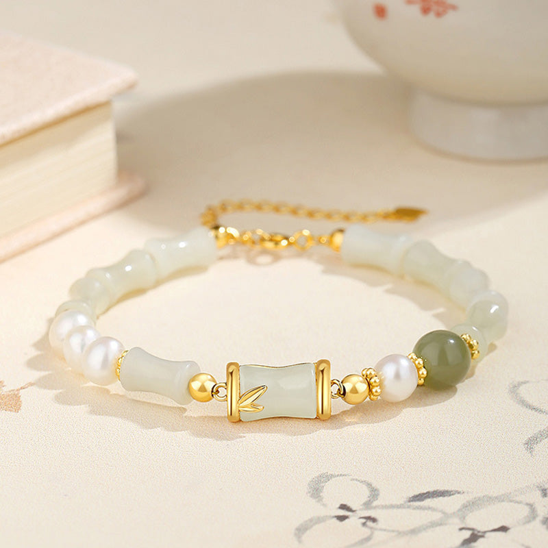 Weißes Jade Bambus Armband mit Perlen und Goldakzenten elegant präsentiert.