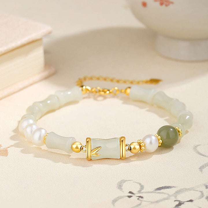 Weißes Jade Bambus Armband mit Perlen und Goldakzenten elegant präsentiert.