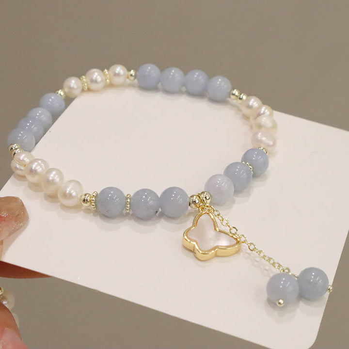 Armband Aquamarin Perle Schmetterling Gold Charm elegant Handgelenk getragen